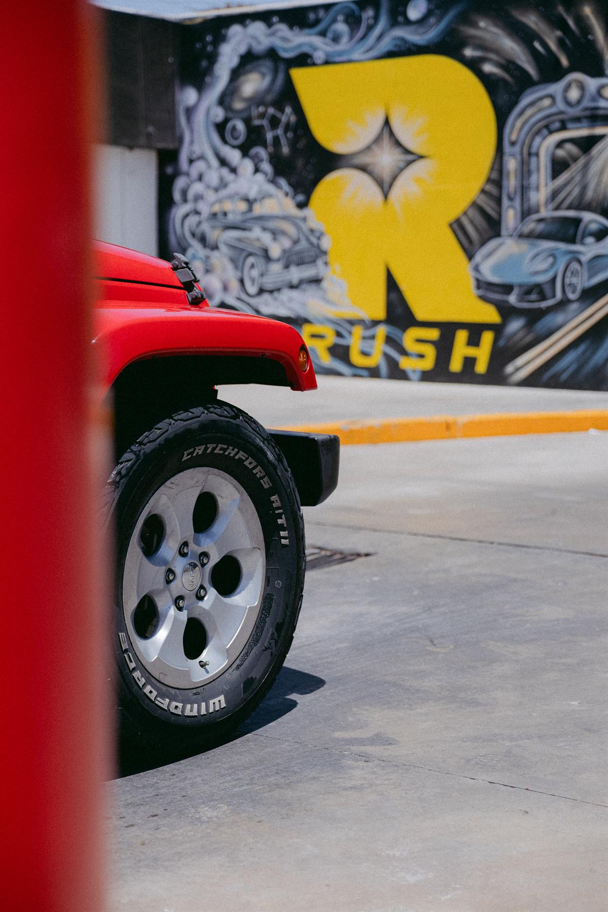 Rin de Jeep frente al mural de RUSH